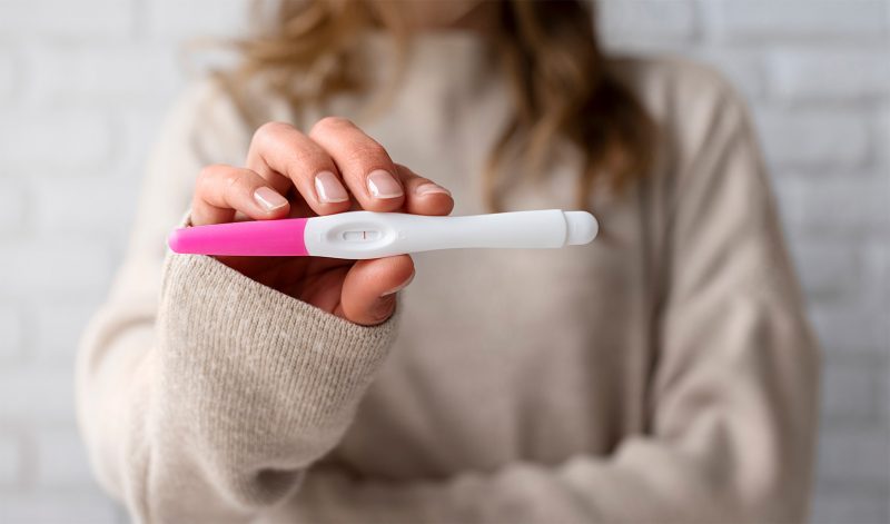 Негативний тест на вагітність в руках у жінки