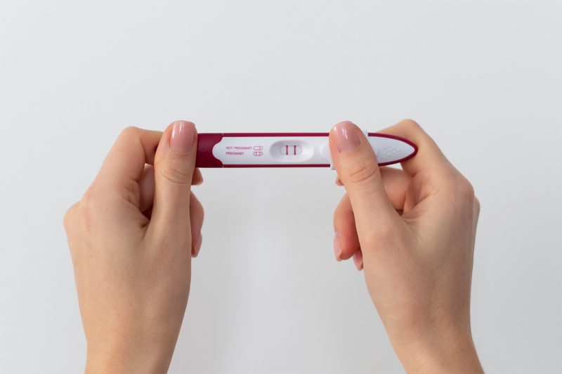 Позитивний тест на вагітність в руках жінки